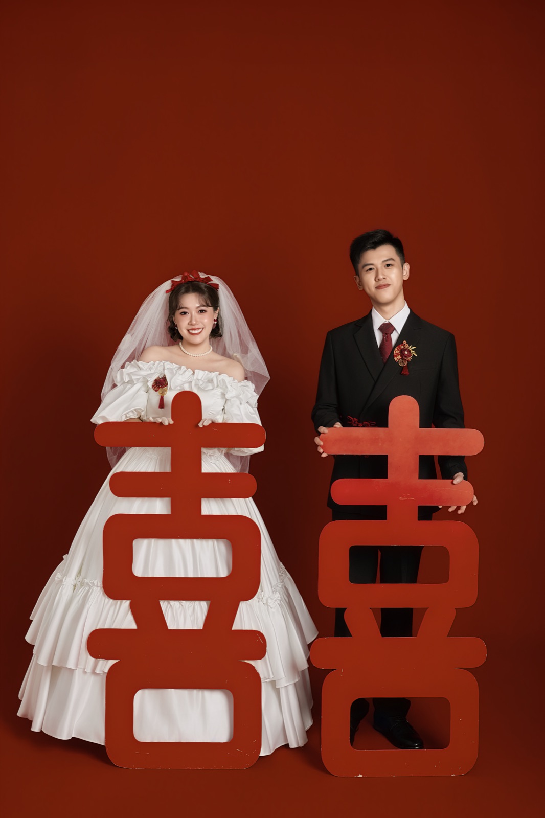Zhi Yang and Chang Jing holding double-happiness signs in wedding attire