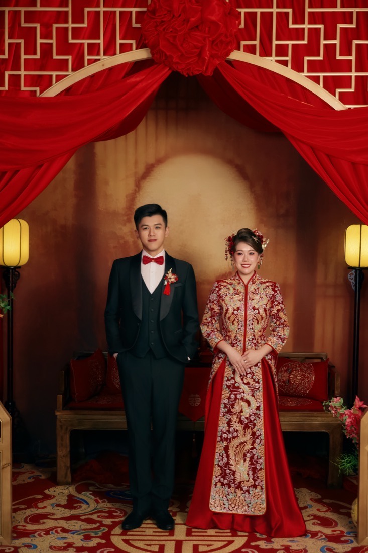 Zhi Yang and Chang Jing beneath a traditional red wedding canopy